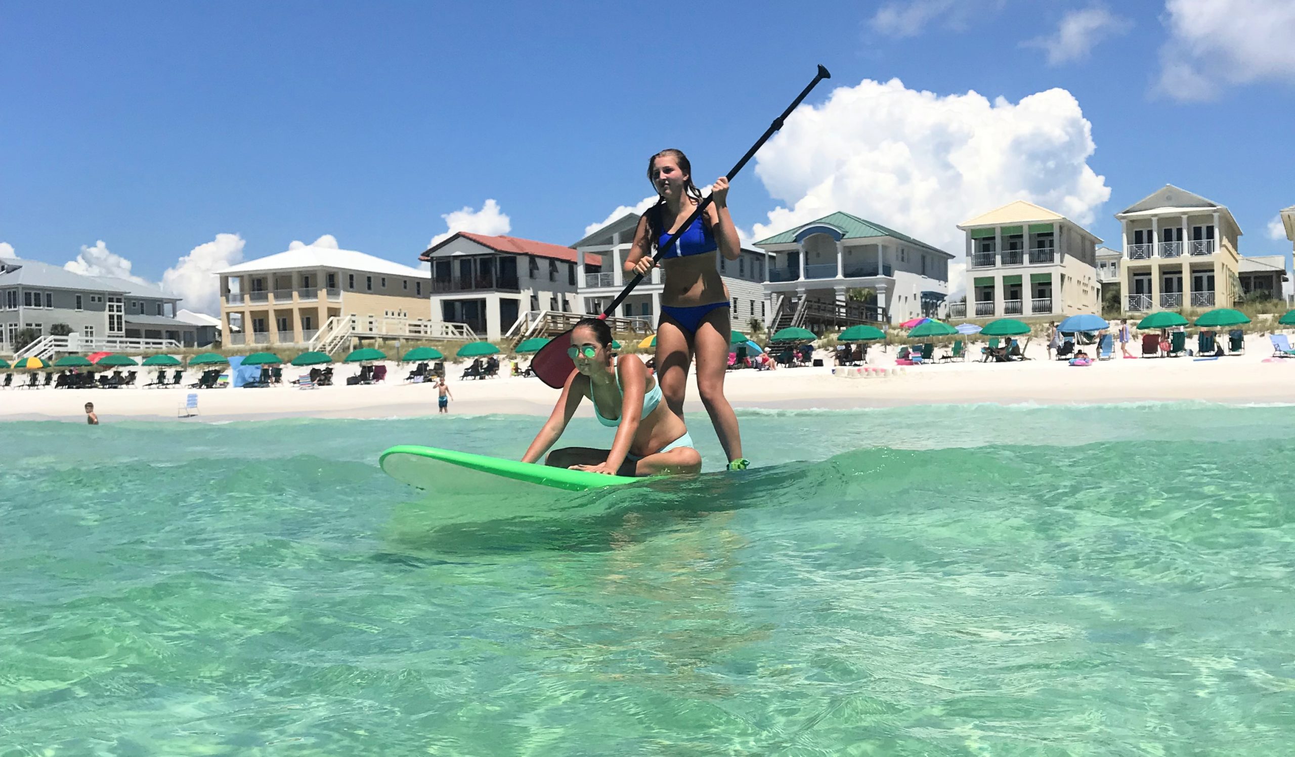 teenagers paddleboarding in the Gulf of Mexico at Destin Pointe teenagers paddleboarding in the Gulf of Mexico at Destin Pointe